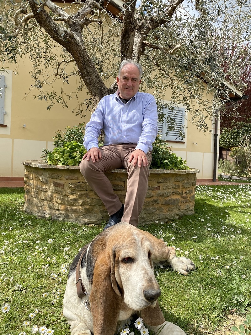 Man sitting in a garden with a basset hound